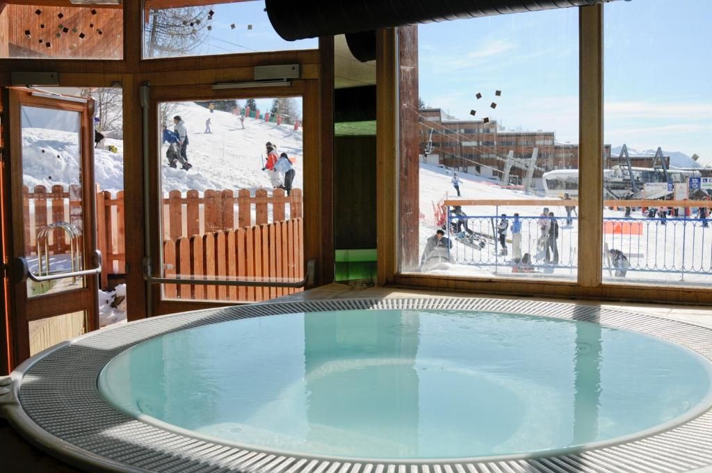 Un bain à remous avec vue sur une piste de ski enneigée.