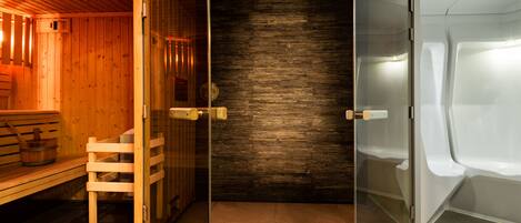Una sala de sauna con bancos de madera, una puerta de cristal y suelo de baldosas.