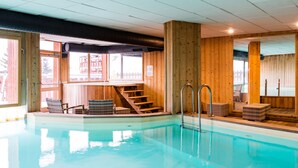 Una piscina interior con paredes de madera y una escalera que conduce a una terraza.