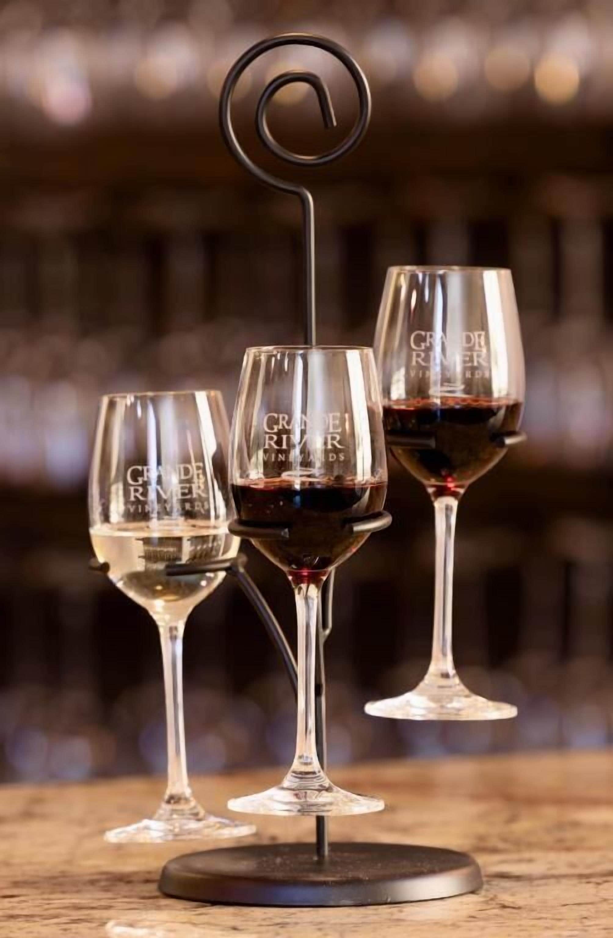 Three wine glasses on a stand with a blurred background.