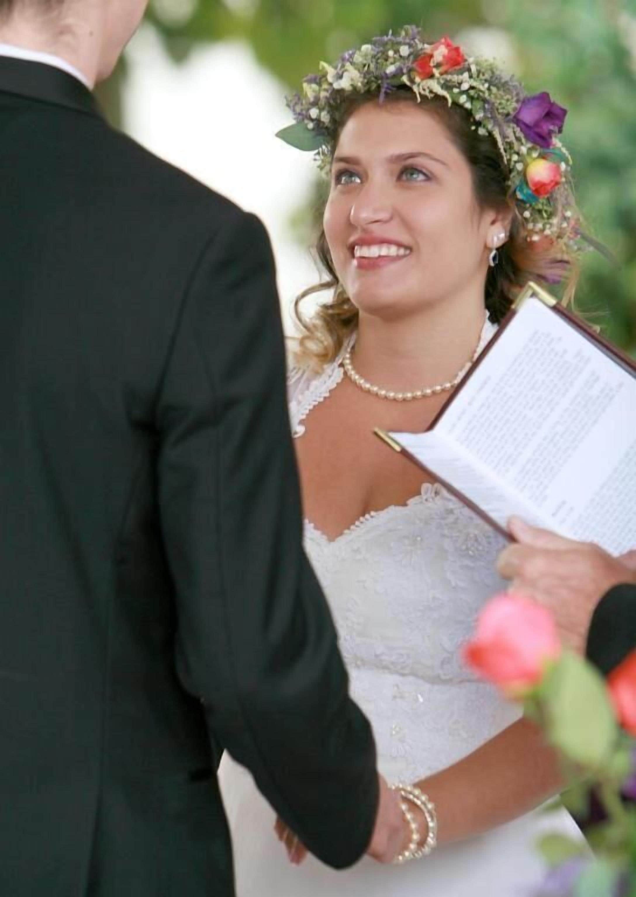 A wedding ceremony with a couple holding a book, likely a wedding program.