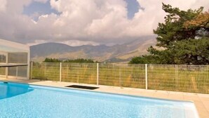 A swimming pool with a glass-enclosed area and a view of mountains. - Madame Vacances Résidence La Crête du Berger (Le Dévoluy)