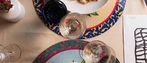 Una mesa de comedor con dos platos de pasta de mariscos y una copa de vino.