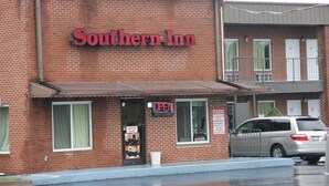 A Southern Inn building with a brick facade, an 'OPEN' sign, and a visible office window. - Southern Inn Lumberton (Lumberton)