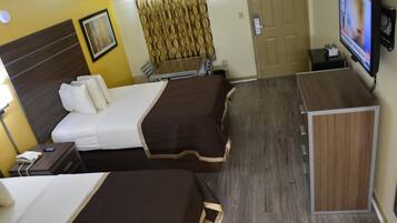 A hotel room with two beds, a TV, a desk, and a wardrobe.