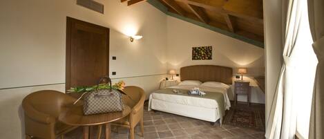 Une chambre d’hôtel avec un lit, une table de chevet, une chaise et une petite table sur laquelle se trouve un sac à main.