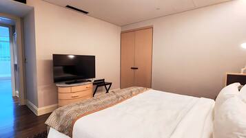 A hotel room with a bed, a TV, a dresser, and a wardrobe.