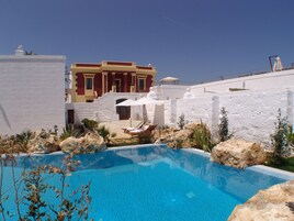 季节性开放的室外游泳池，10:00 至 14:00 开放，池畔遮阳伞，日光浴躺椅