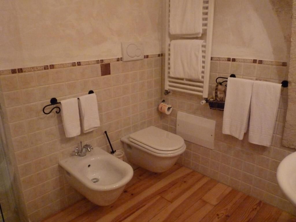 A bathroom with a bidet, toilet, and sink.