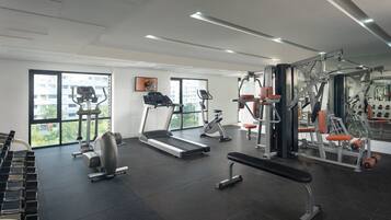 A modern gym with treadmills, weight machines, and benches.