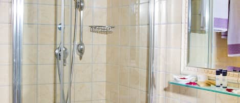 Un box de ducha con paredes de vidrio, un lavabo blanco y un espejo encima.