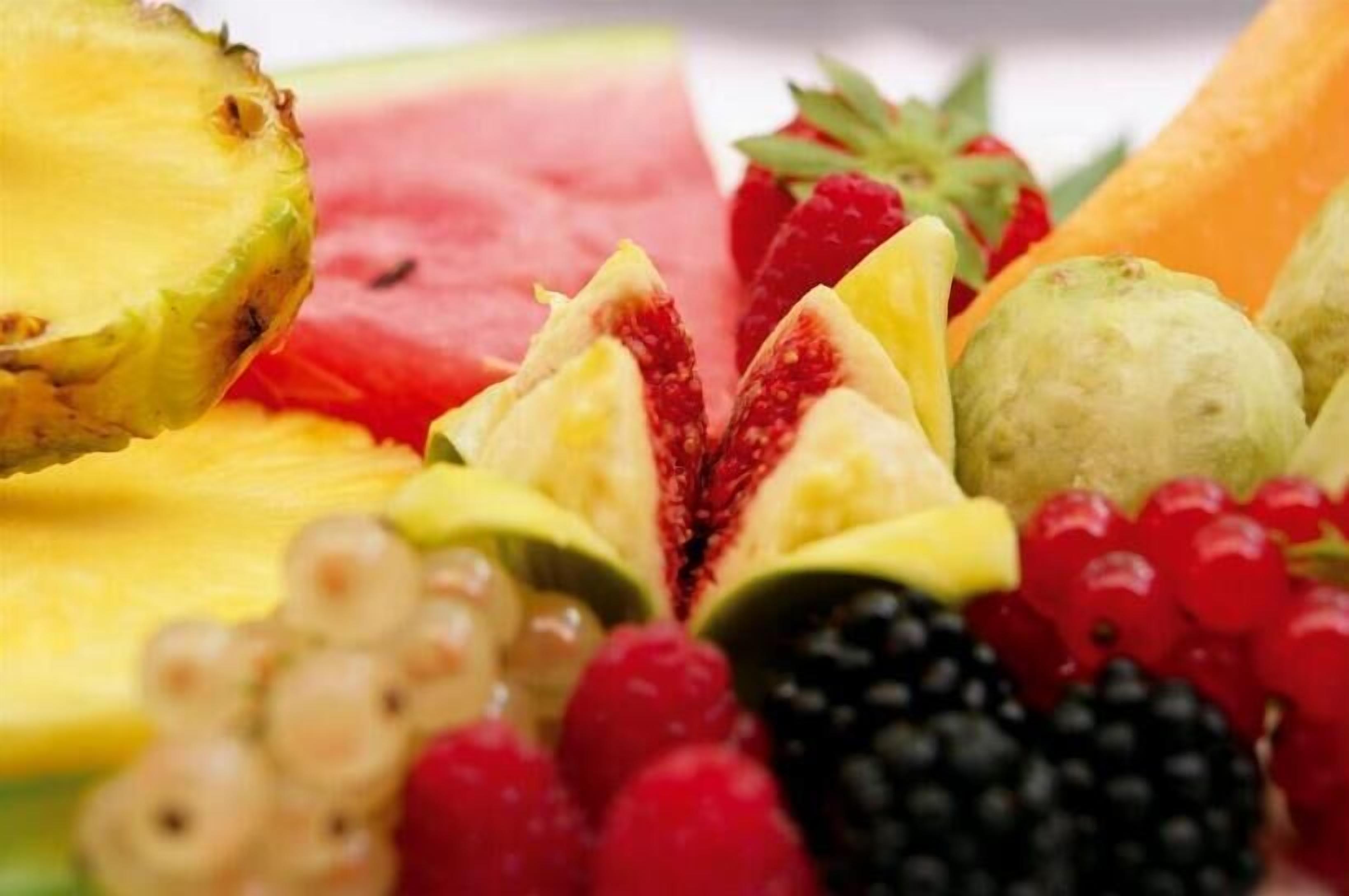 Una variedad de frutas frescas como sandía, piña, uvas, fresas y frambuesas.