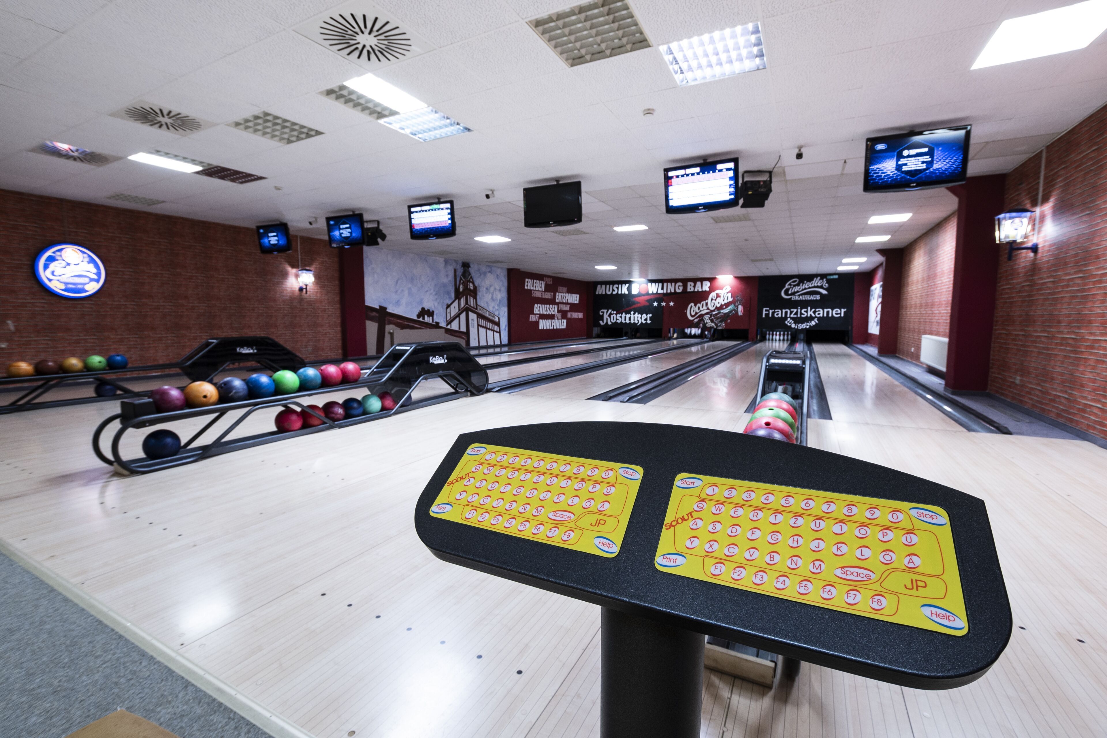 Bolera con múltiples pistas, bolas de bolos y un sistema de devolución de bolas.