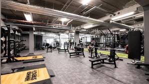 Uma academia com diversos equipamentos de exercício, incluindo máquinas de peso e bancos.