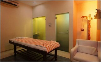 A room with a bed, a chair, and a scale.