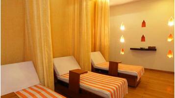 Three single beds with striped bedspreads and wooden nightstands, set against a neutral backdrop.