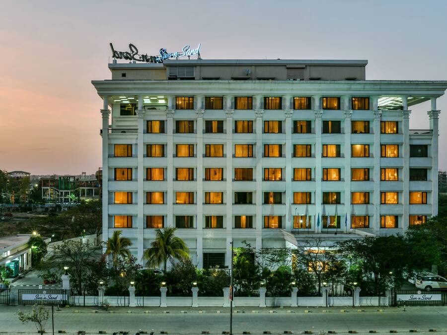 A multi-story hotel with a classic architectural design, featuring a prominent sign at the top.