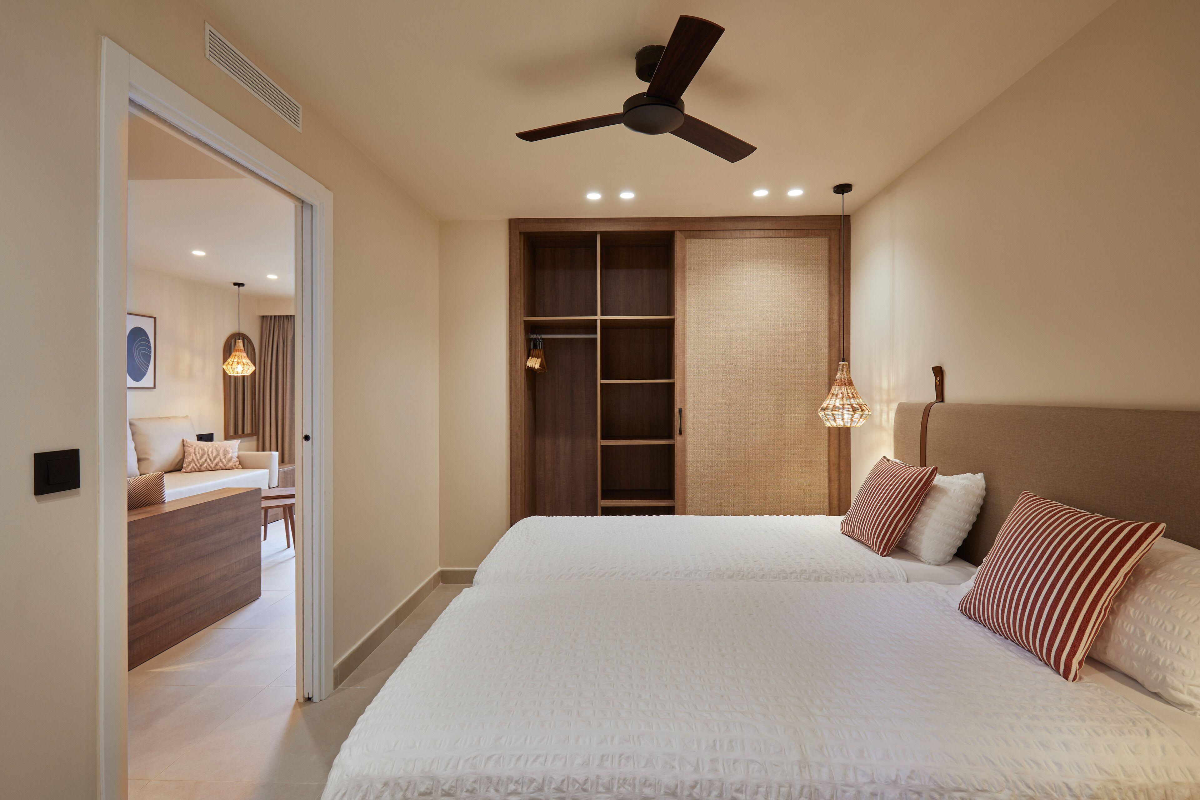 Een slaapkamer met een groot bed, een plafondventilator en een inloopkast.