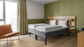 Une chambre d’hôtel moderne, équipée d’un lit, d’une chaise et d’un bureau.