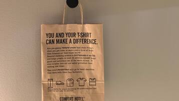 A wall-mounted hook with a paper bag hanging from it.