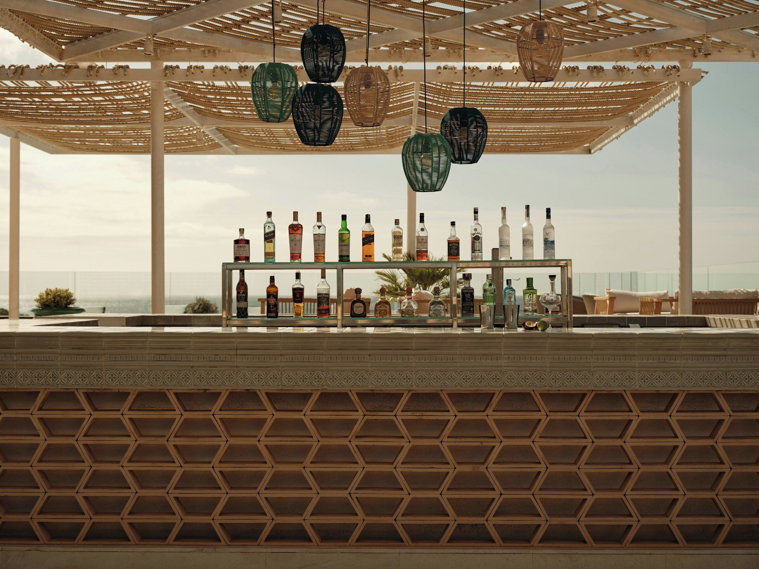 A bar area with bottles and a view of the sea.