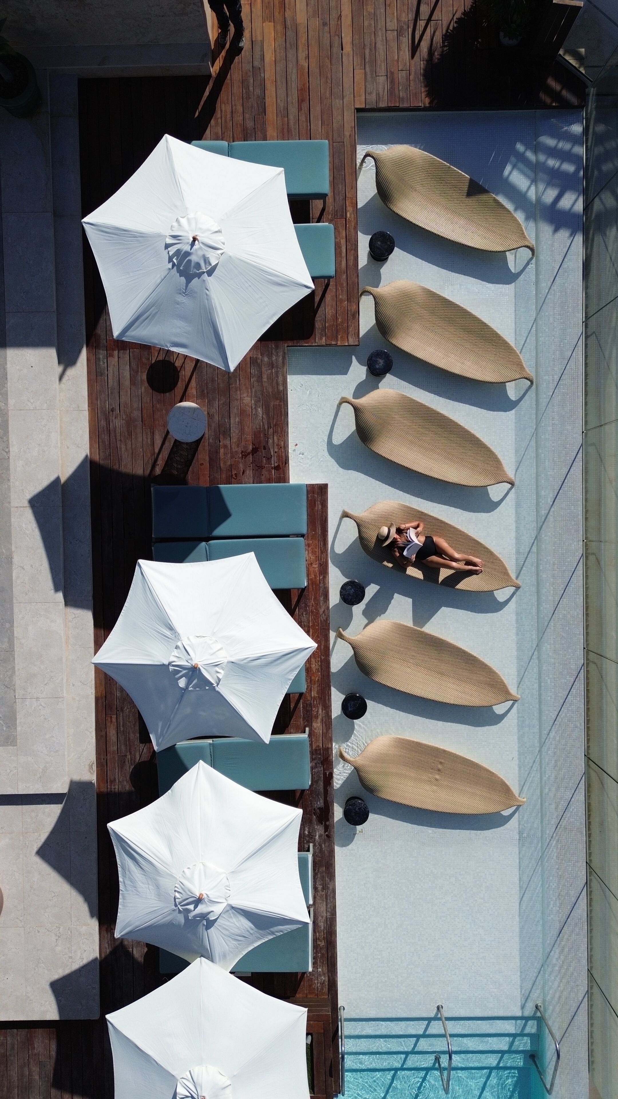 An outdoor pool area with lounge chairs and umbrellas.