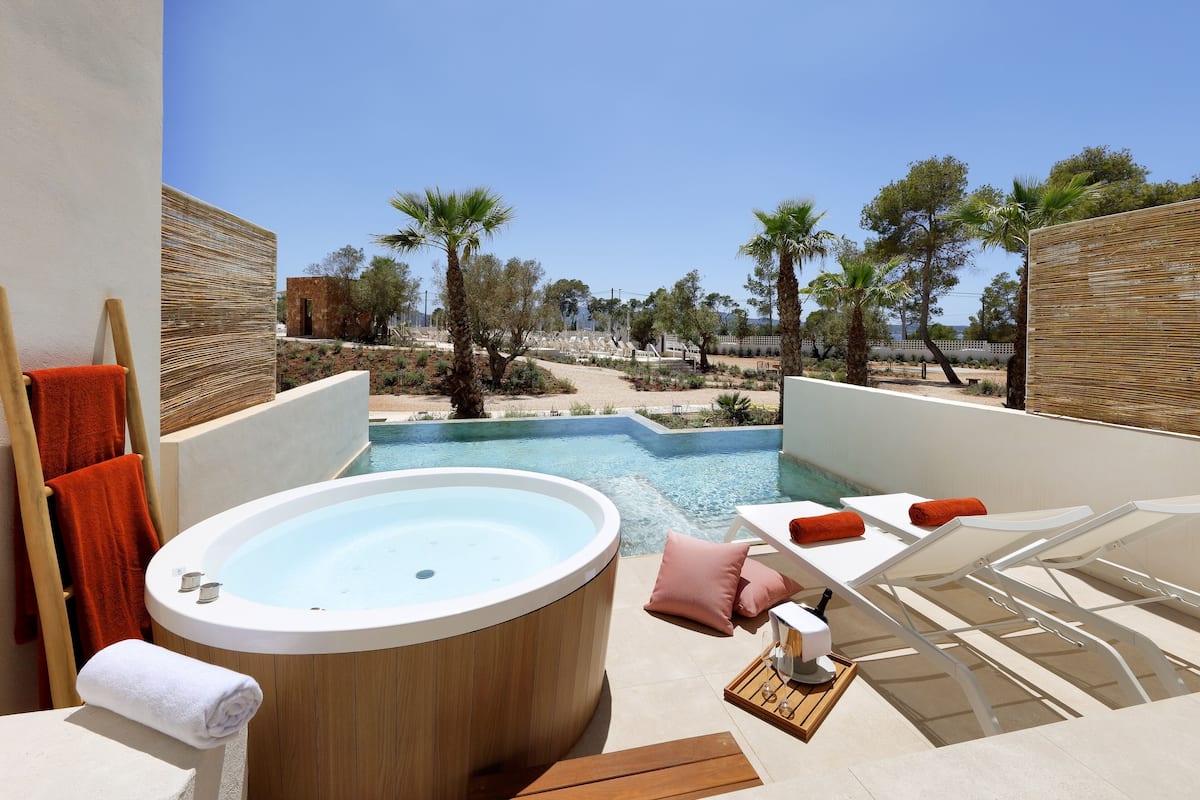 Un jacuzzi con vista a una piscina y palmeras.
