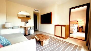 A hotel room with a bed, a desk, a chair, a TV, and a mirror.