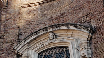 Un bâtiment historique doté d’une grande fenêtre en arc de cercle et d’une porte verte.