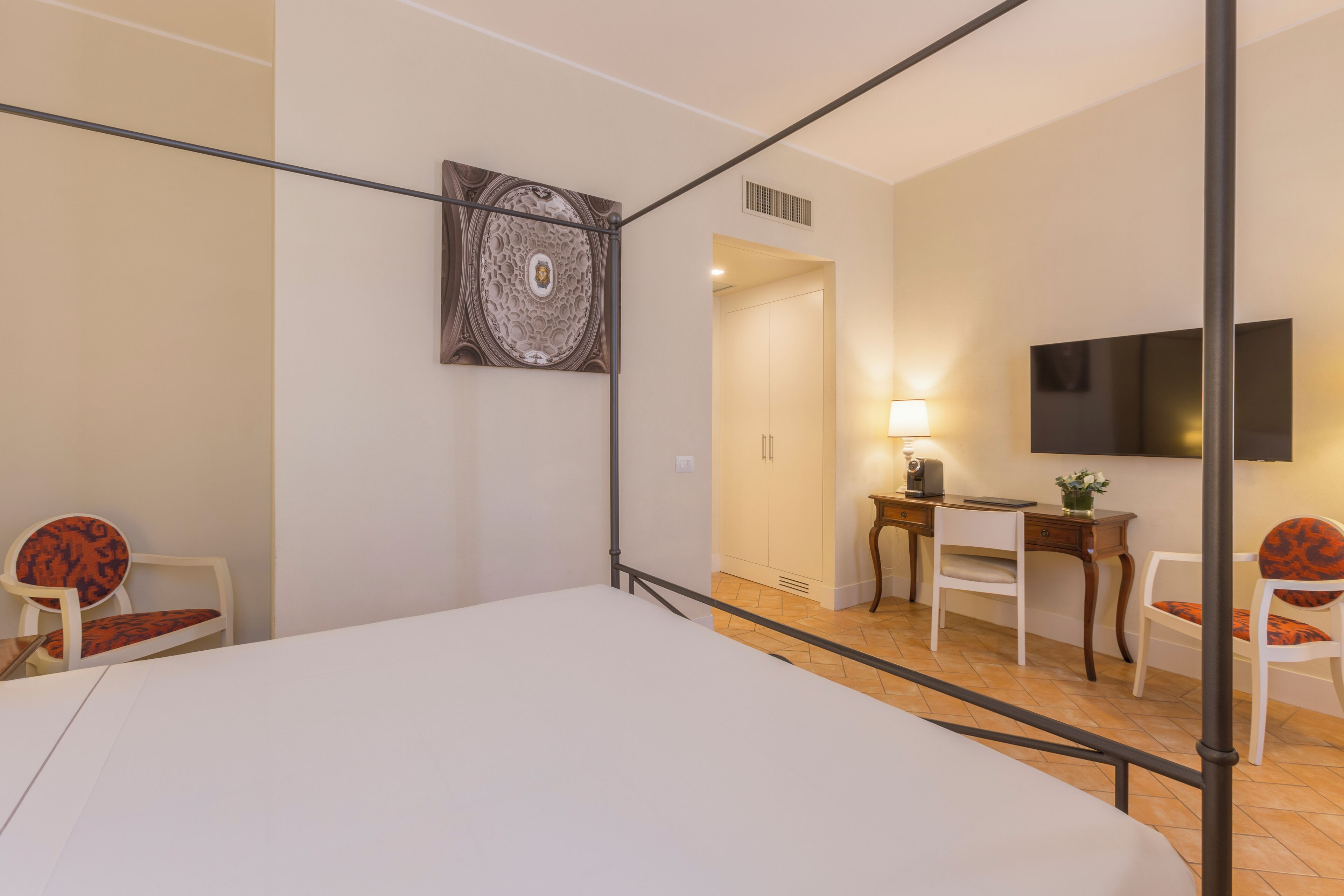 Una habitación moderna con una cama, un escritorio y una televisión.