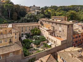 A courtyard with buildings, a fountain, and trees.