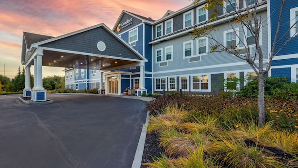 A hotel with a covered entrance, multiple floors, and a landscaped garden. - Comfort Inn & Suites Wilton (Wilton)