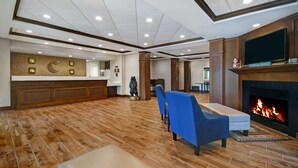 A spacious lobby with a fireplace, seating area, and a reception desk. - Comfort Inn & Suites Wilton (Wilton)
