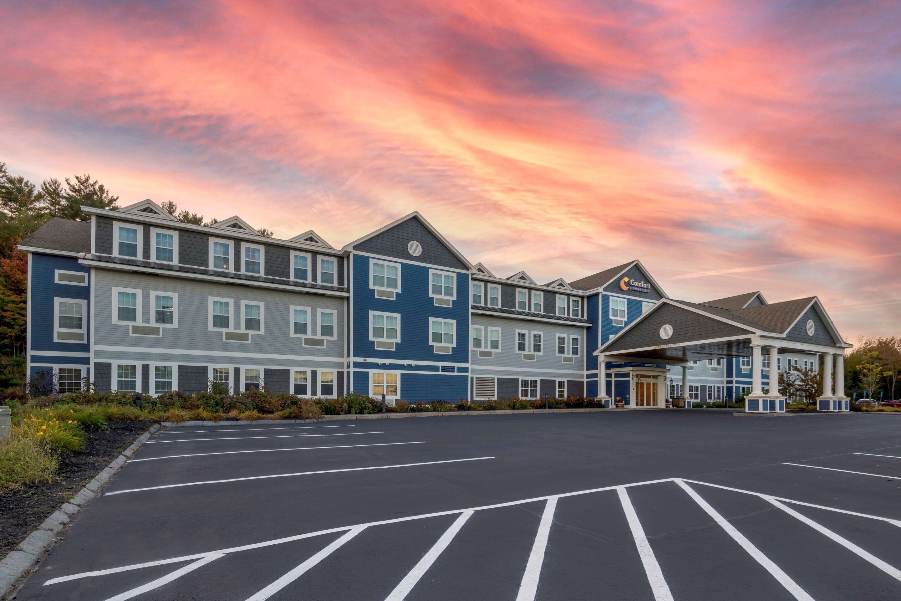 A multi-story hotel with a parking lot in front.