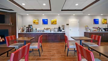 A restaurant with a central counter, seating area, and a fireplace.