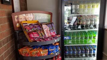 A vending machine stocked with snacks and a Pepsi refrigerator.