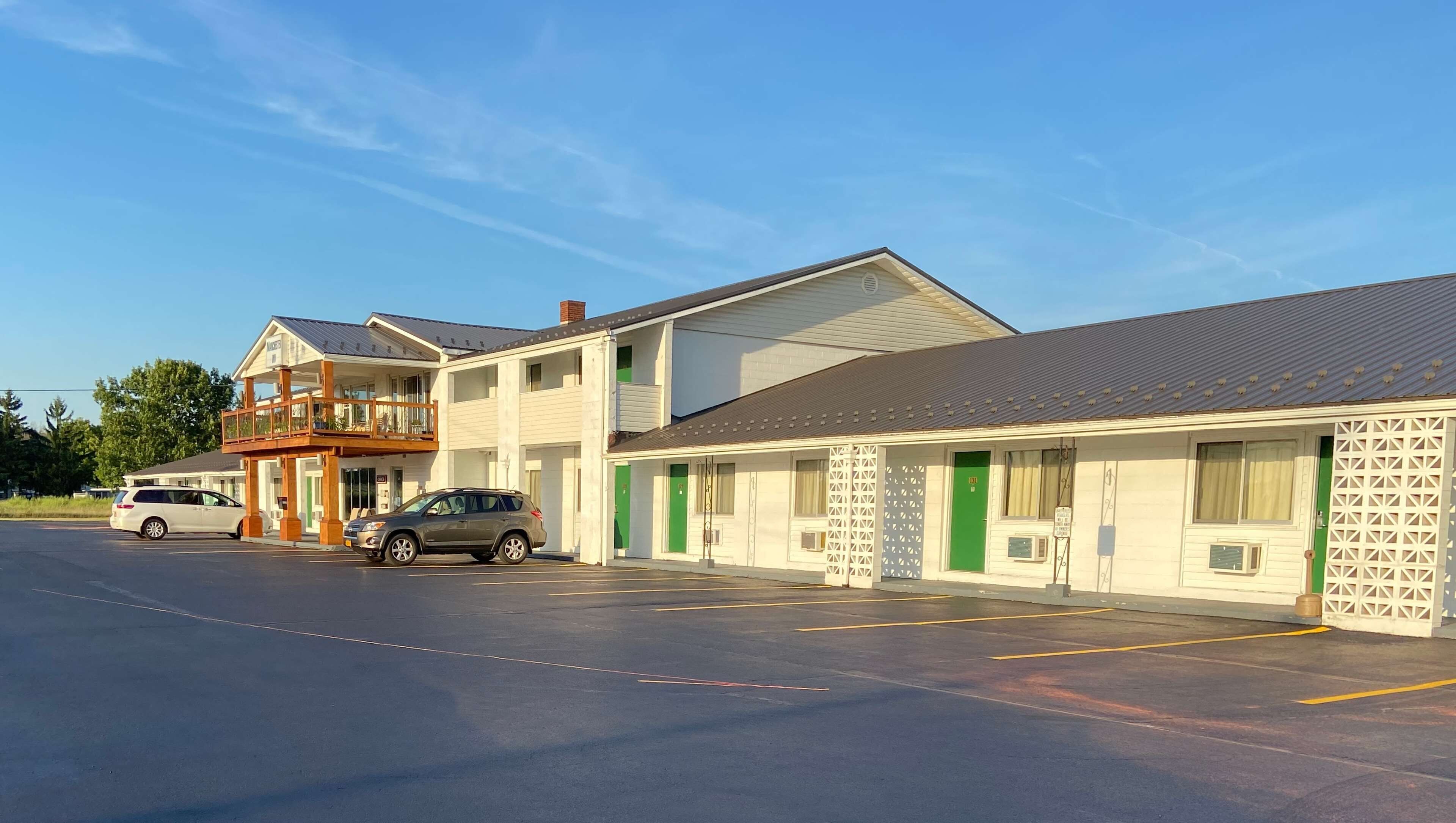 A motel with multiple rooms, a parking lot, and a small balcony.