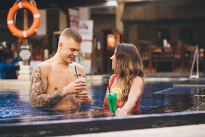 Una piscina al aire libre, sillones reclinables de piscina