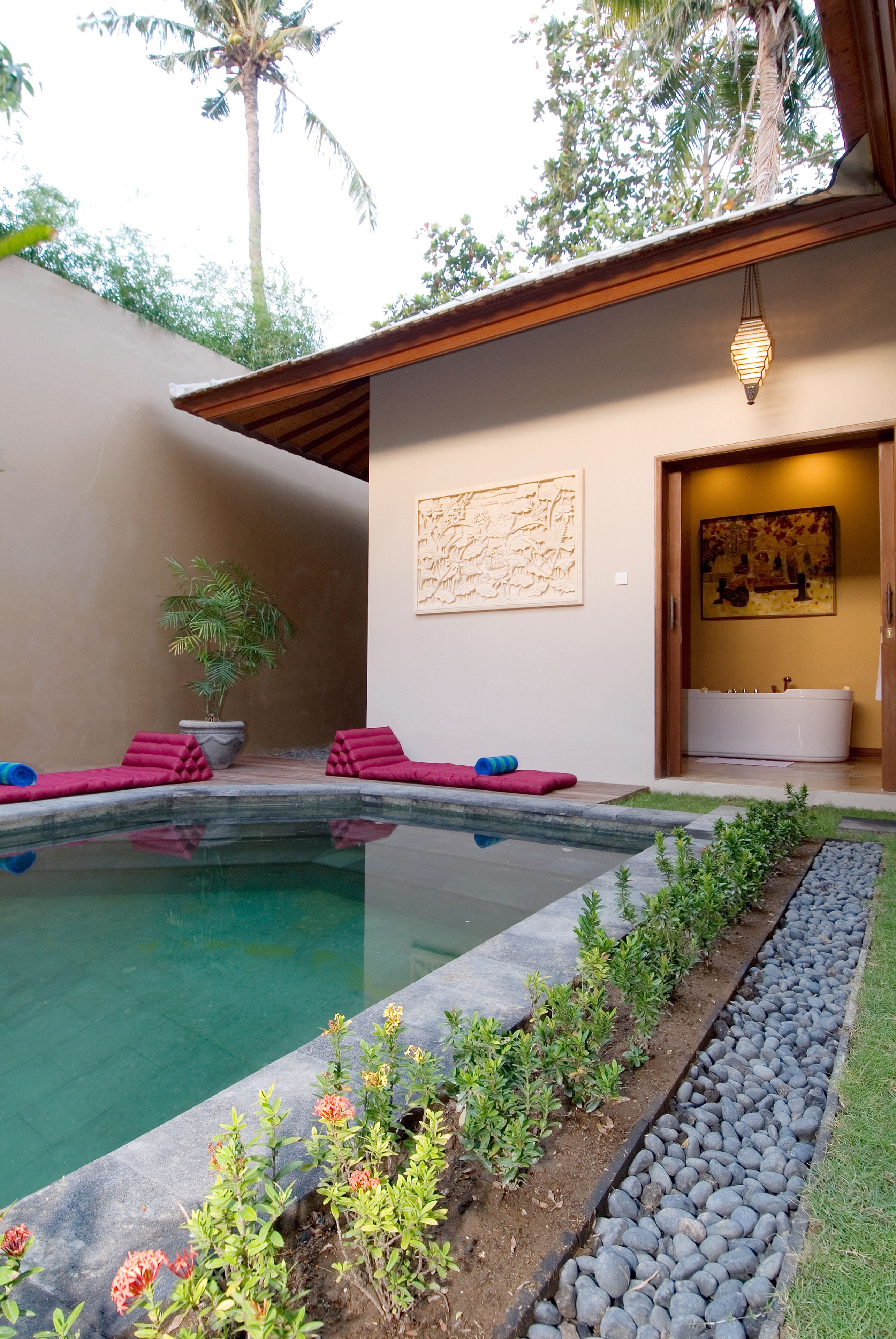 Un espace piscine extérieur moderne, doté d’un jacuzzi, entouré d’un jardin bien entretenu et d’une piscine à l’eau claire.