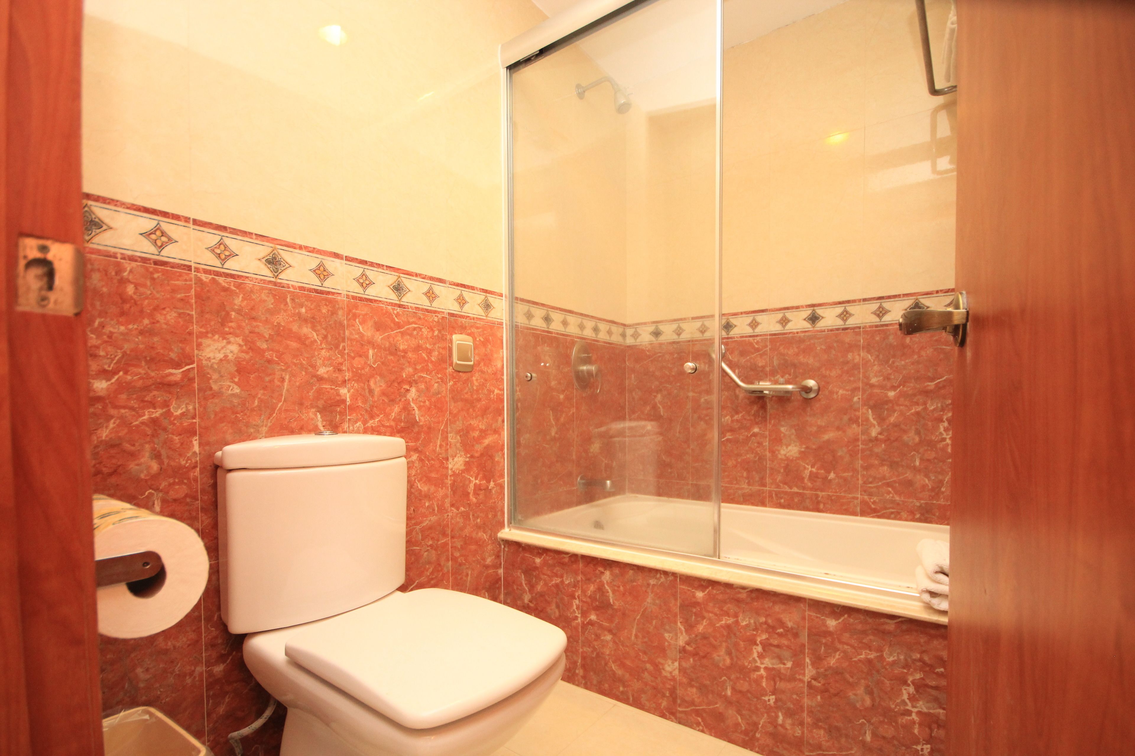 A bathroom with a toilet, a shower, and a bathtub.