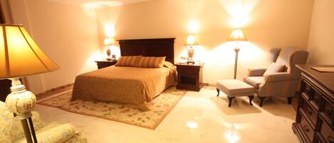 A hotel room with a bed, two bedside tables with lamps, a chair, a dresser, and a floor lamp.