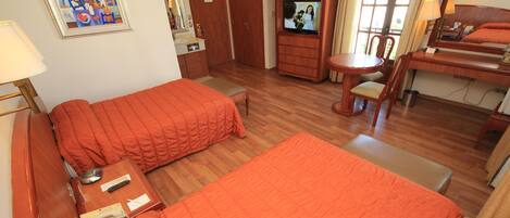 Une chambre d’hôtel avec deux lits, une télévision, un bureau et une chaise.