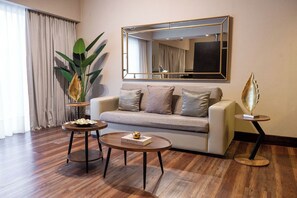 A modern living room with a sofa, two coffee tables, a large mirror, and a potted plant. - The Glu Boutique Hotel - Palermo Soho (Buenos Aires)