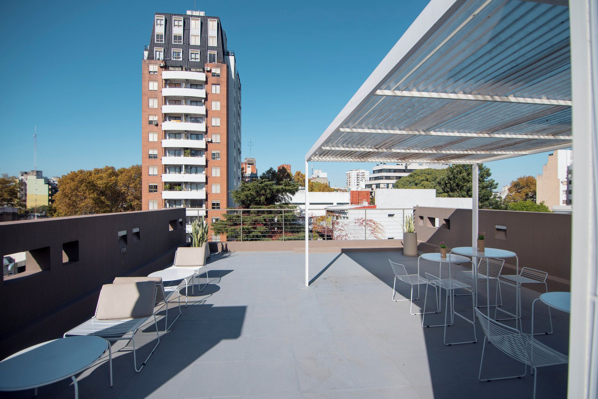 An outdoor terrace with seating and a view of a tall building.