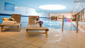 A poolside area with lounge chairs, a table with amenities, and a view of the pool. - Talbot Hotel Carlow (Carlow)