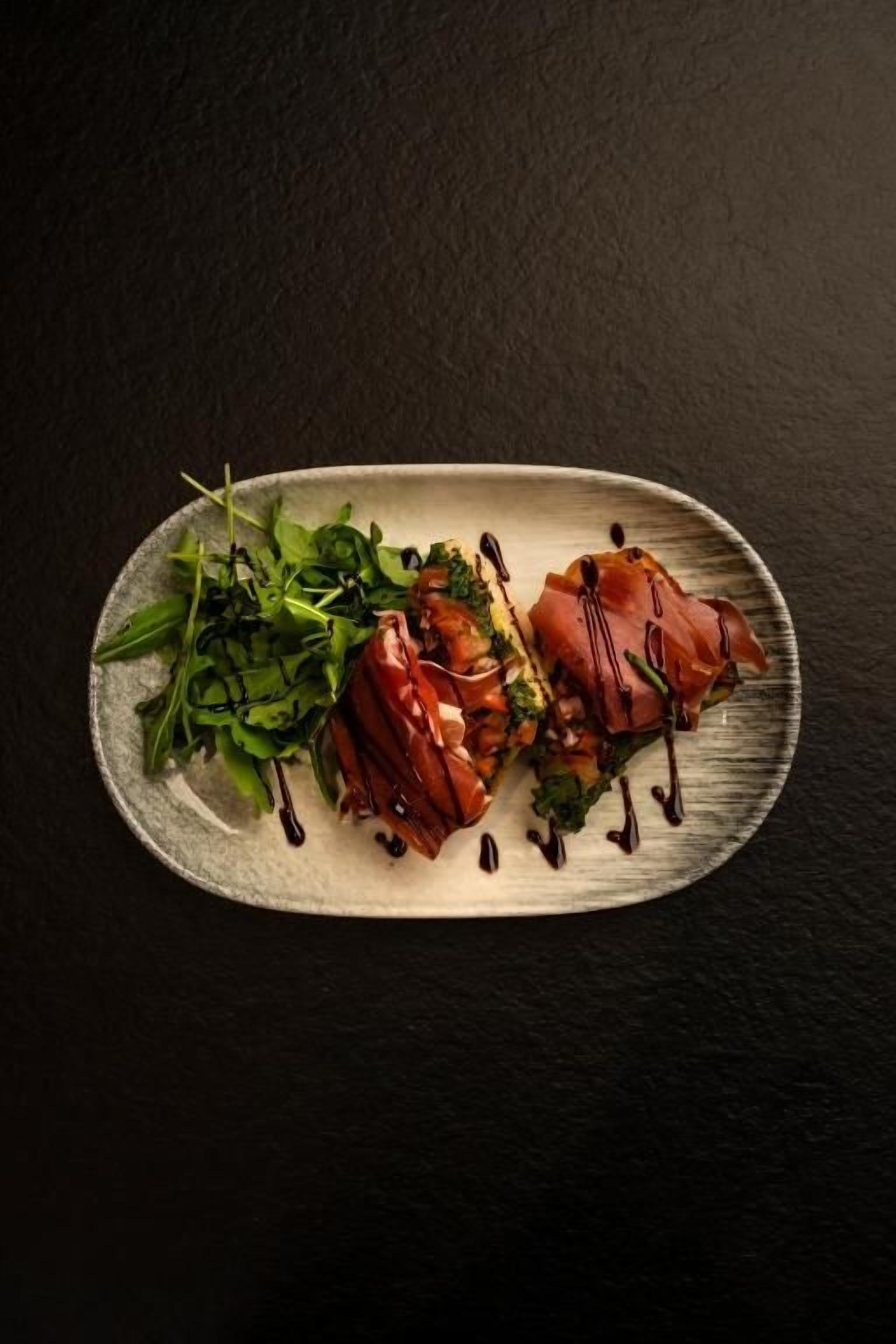 A rectangular plate with food items on a dark surface.