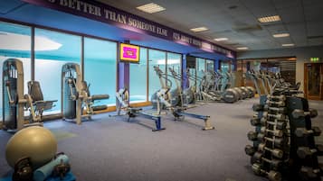 A gym with various exercise equipment, including treadmills, elliptical machines, and free weights.