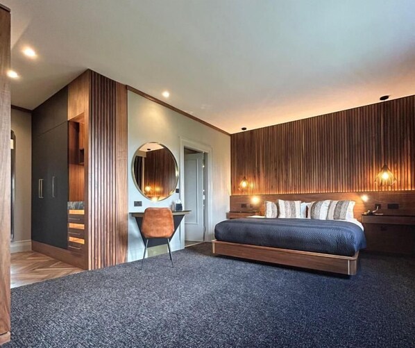 Un dormitorio moderno con una cama grande, un espejo redondo y paneles de madera empotrados en las paredes.