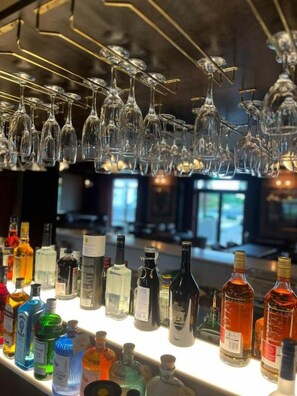 A bar area with multiple bottles and glasses.
