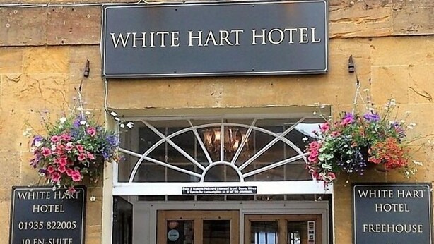 The exterior of the White Hart Hotel with a sign indicating it has 10 en-suite rooms, WiFi, and a car park. - White Hart Hotel (Martock)